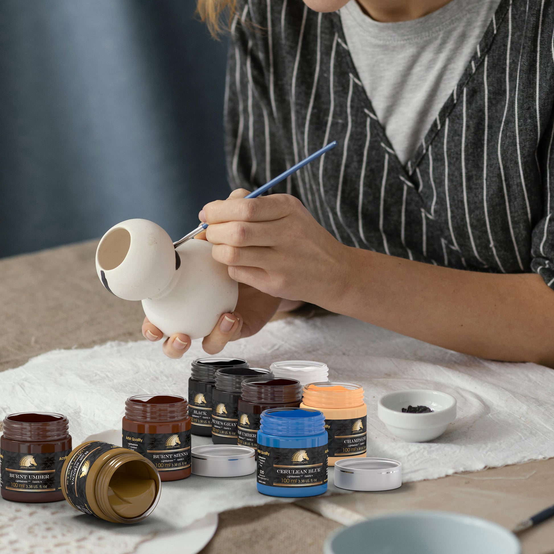 A woman is painting a ceramic